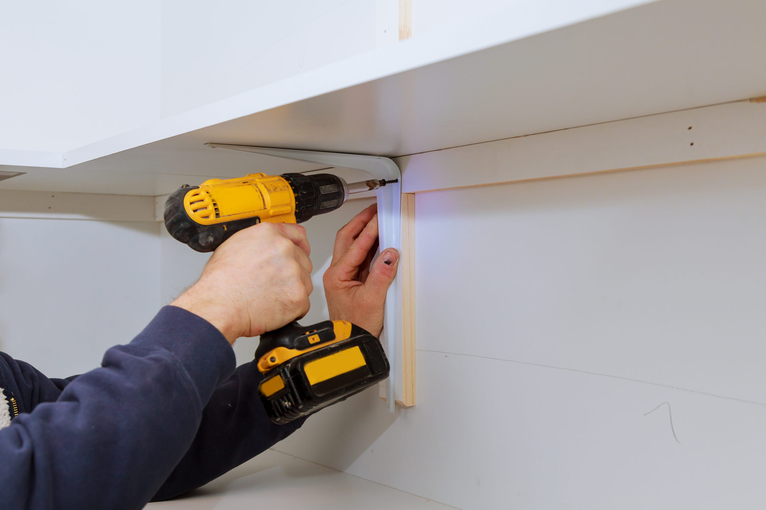 Man installing wooden shelves on brackets installation of shelves