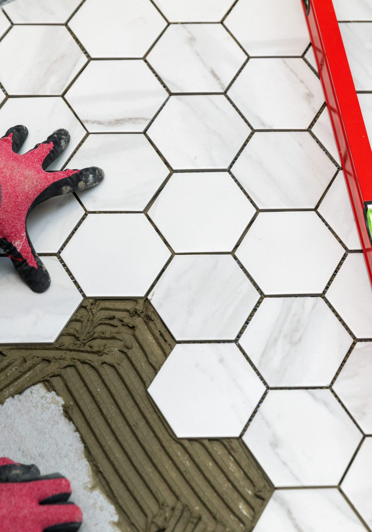 tiler laying marble texture hexagon tiles on the bathroom floor